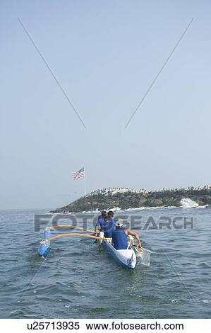 Stock Photography - Outrigger canoeing team on water. Fotosearch