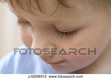 Young boy looks down concentrating View Large Photo Image Stock Photography - Young boy looks down concentrating. Fotosearch