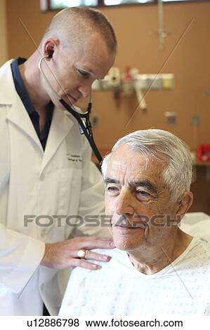 Young doctor listens to young elderly man's breathing View Large Photo Image Stock Photo - Young doctor listens to young elderly man's breathing. Fotosearch