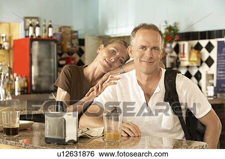 Stock Photograph - Affectionate couple sitting in bar, portrait. Fotosearch