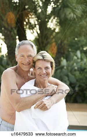 Stock Image - Affectionate Senior Couple at Poolside. Fotosearch