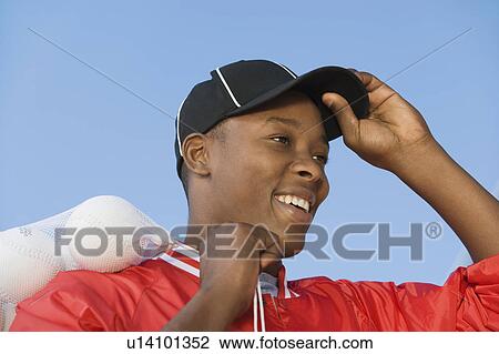 Ball boy ajusting hat in softball game View Large Photo Image Stock Image - Ball boy ajusting hat in softball game. Fotosearch