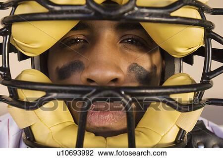 Stock Image - Baseball catcher wearing mask, (close-up), (portrait). Fotosearch