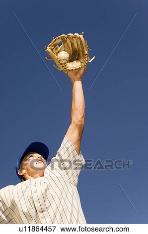 Baseball player catching ball in baseball glove, (low angle view) View Large Photo Image Stock Photo - Baseball player catching ball in baseball glove, (low angle view). Fotosearch