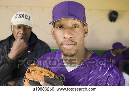 Stock Photograph - Baseball player in dugout with coach, (portrait). Fotosearch