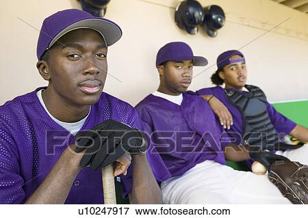 Stock Photo - Baseball players sitting in dugout, (portrait). Fotosearch