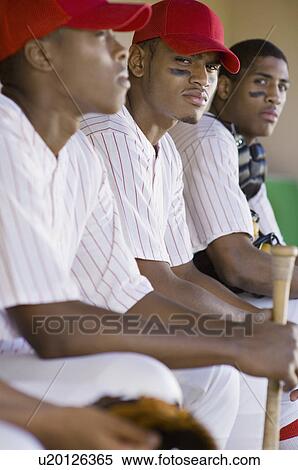 Stock Photography - Baseball players sitting in dugout. Fotosearch