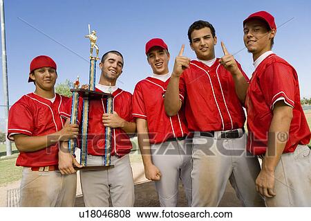 Baseball team-mates holding trophy on field View Large Photo Image Stock Photo - Baseball team-mates holding trophy on field. Fotosearch