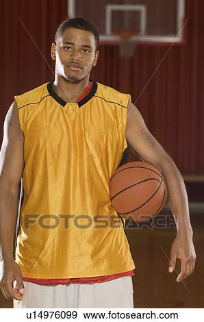 Stock Photo - Basketball player with ball on indoor court, (portrait). Fotosearch