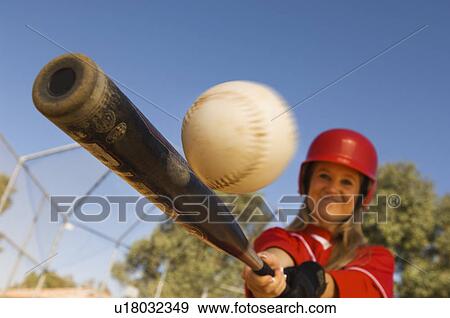 Stock Photo - Batter hitting softball, portrait. Fotosearch