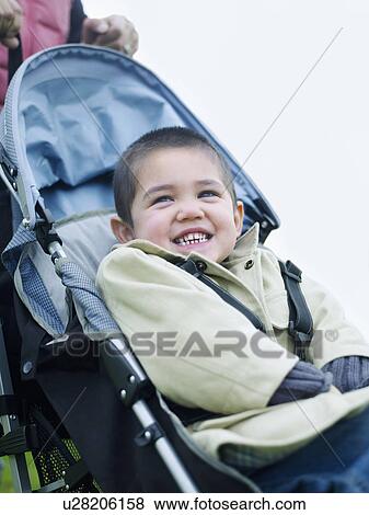 Boy (3-4) sitting in stroller, portrait View Large Photo Image Stock Photo - Boy (3-4) sitting in stroller, portrait. Fotosearch