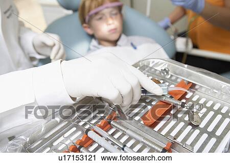 Stock Image - Boy (6-9) at dental surgery. Fotosearch