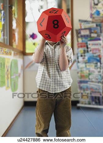 Boy holding oversize twelve-sided dice in classroom View Large Photo Image Stock Photograph - Boy holding oversize twelve-sided dice in classroom. Fotosearch