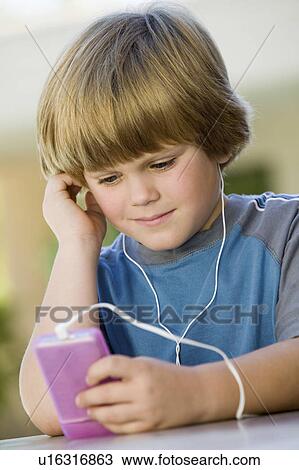 Stock Image - Boy Listening to Music on MP3 Player. Fotosearch