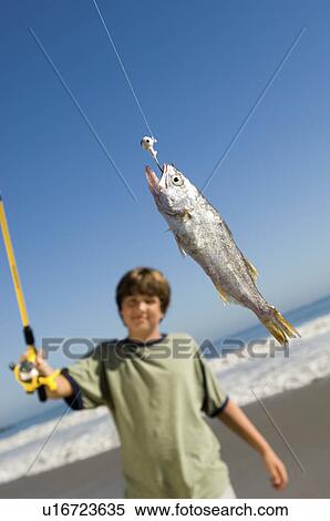 Boy on beach displaying fish on fishing rod View Large Photo Image Stock Photography - Boy on beach displaying fish on fishing rod. Fotosearch