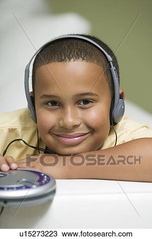 Boy on sofa Listening to portable CD player, portrait View Large Photo Image Stock Image - Boy on sofa Listening to portable CD player, portrait. Fotosearch