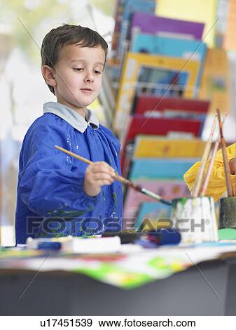 Boy painting in art class View Large Photo Image Stock Photo - Boy painting in art class. Fotosearch