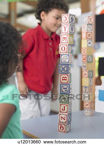 Stock Image - Boy playing with alphabet blocks in classroom. Fotosearch