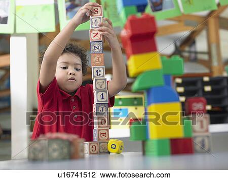Boy playing with alphabet blocks in classroom View Large Photo Image Stock Image - Boy playing with alphabet blocks in classroom. Fotosearch