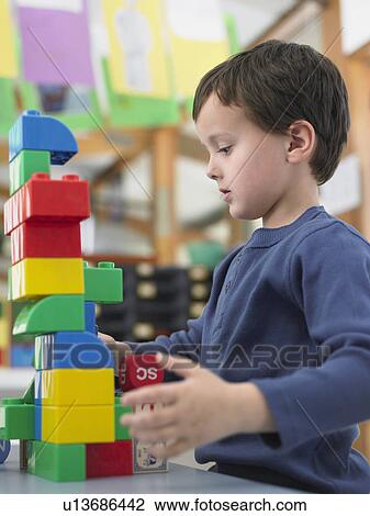 Boy playing with building blocks in classroom View Large Photo Image Stock Image - Boy playing with building blocks in classroom. Fotosearch