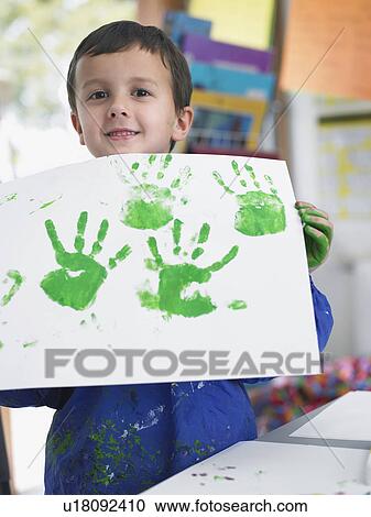 Boy presenting his finger painting in art class View Large Photo Image Stock Image - Boy presenting his finger painting in art class. Fotosearch