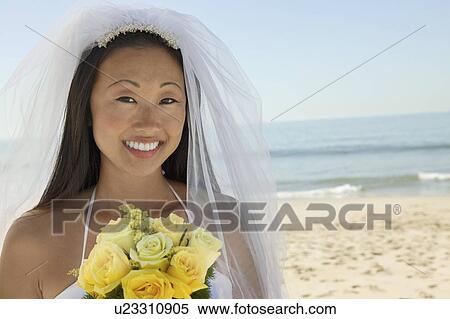 Bride with bouquet on beach, (close-up), (portrait) View Large Photo Image Stock Photography - Bride with bouquet on beach, (close-up), (portrait). Fotosearch