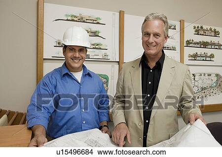 Builder and architect discussing blueprint, portrait View Large Photo Image Picture - Builder and architect discussing blueprint, portrait. Fotosearch