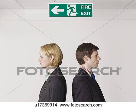 Picture - Business colleagues standing under exit sign. Fotosearch
