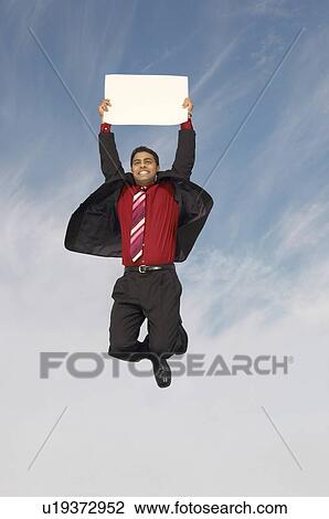 Business man jumping with blank sign outdoors View Large Photo Image Stock Image - Business man jumping with blank sign outdoors. Fotosearch