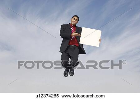 Business man jumping with blank sign outdoors View Large Photo Image Stock Photography - Business man jumping with blank sign outdoors. Fotosearch