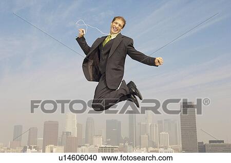 Business man listening to mp3 player mid-air above city View Large Photo Image Stock Image - Business man listening to mp3 player mid-air above city. Fotosearch