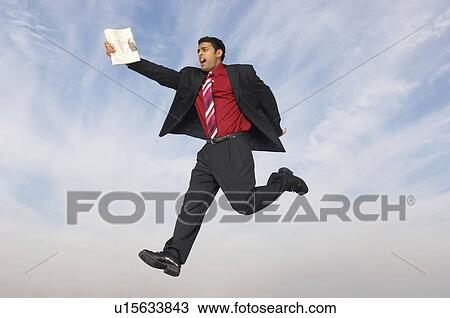 Business man running with newspaper mid-air outdoors View Large Photo Image Stock Image - Business man running with newspaper mid-air outdoors. Fotosearch