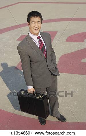 Business man standing in parking lot View Large Photo Image Stock Photo - Business man standing in parking lot. Fotosearch