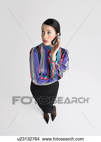 Picture - Business Woman on cell phone in Studio, elevated view. Fotosearch
