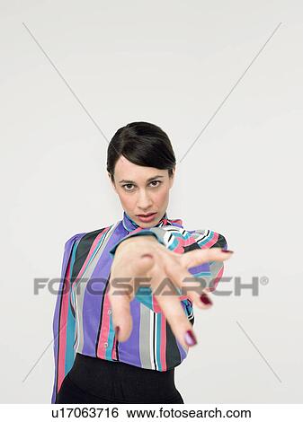 Stock Photograph - Business woman pointing in Studio. Fotosearch