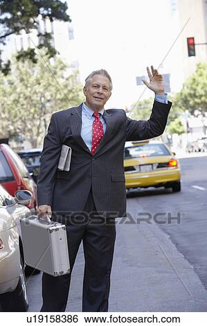 Businessman hailing a cab View Large Photo Image Stock Photograph - Businessman hailing a cab. Fotosearch