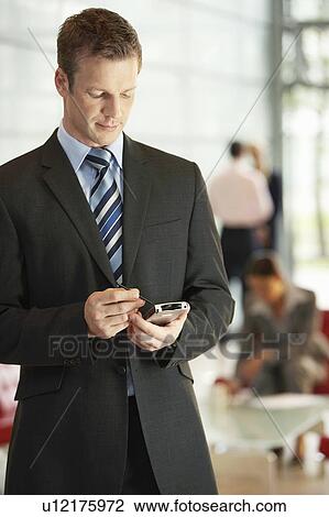 Businessman in Office Using PDA View Large Photo Image Stock Image - Businessman in Office Using PDA. Fotosearch