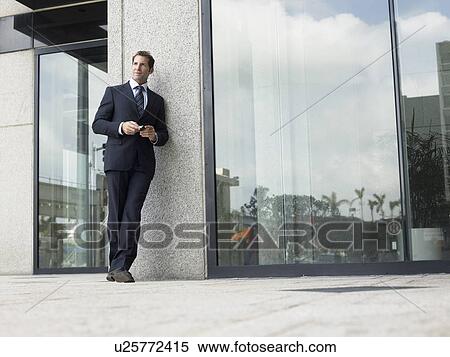 Stock Photography - Businessman outside office building. Fotosearch