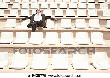 Stock Photograph - Businessman Relaxing in Auditorium, front view.. Fotosearch