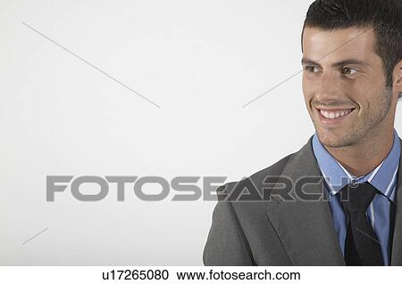Stock Image - Businessman smiling, on white background, portrait. Fotosearch