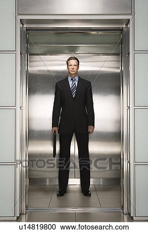 Businessman standing in open Elevator, portrait, front view View Large Photo Image Stock Image - Businessman standing in open Elevator, portrait, front view. Fotosearch