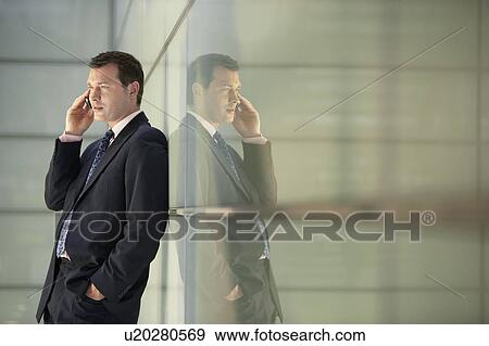 Stock Photo - Businessman Using Cell Phone in Office Corridor. Fotosearch
