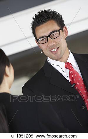Businessman using hands free kit, half-length View Large Photo Image Stock Photography - Businessman using hands free kit, half-length. Fotosearch