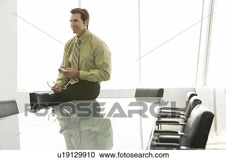 Businessman using remote control in conference room View Large Photo Image Stock Image - Businessman using remote control in conference room. Fotosearch