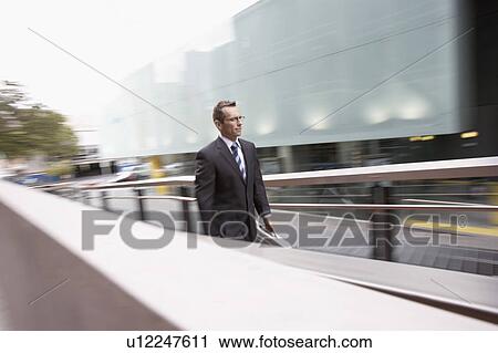 Businessman walking up outdoor ramp View Large Photo Image Stock Image - Businessman walking up outdoor ramp. Fotosearch
