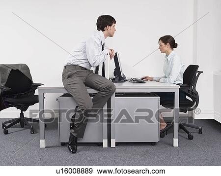 Businessman watching female colleague in office View Large Photo Image Stock Photo - Businessman watching female colleague in office. Fotosearch