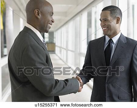 Businessmen shaking hands in hallway View Large Photo Image Stock Image - Businessmen shaking hands in hallway. Fotosearch