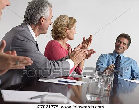 Stock Photography - Businesspeople applauding in conference meeting. Fotosearch
