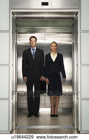 Stock Photo - Businesspeople Side by Side in Elevator, portrait, front view. Fotosearch