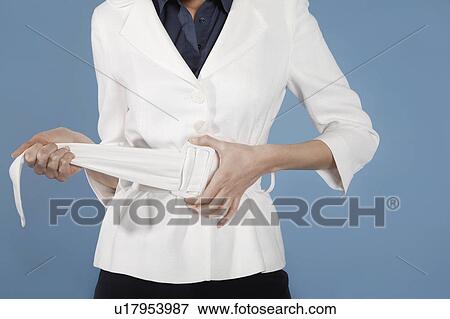Stock Photo - Businesswoman adjusting belt, mid section. Fotosearch